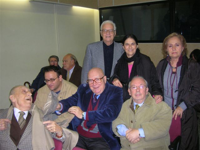 il Presidente del Gruppo dei Romanisti Umberto Mariotti Bianchi, lo scrittore critico Marco Onofrio, il Romanista critico darte Paolo Emilio Trastulli, il Romanista editore Willy Pocino; in piedi, il Romanista archeologo storico Romolo Augusto Staccioli, la critica darte Stefania Severi, la pittrice Anna Addamiano.